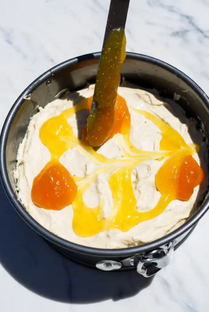 swirling fruit mixture into cheesecake batter