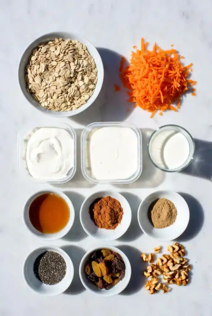 Carrot cake overnight oats ingredients with creamy oats, carrot shreds, and raisins