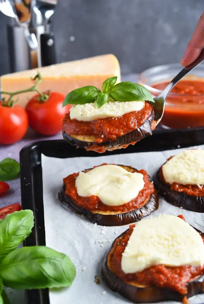 Eggplant Parmesan Stacks recipe layering process with eggplant, marinara, mozzarella, parmesan and basil
