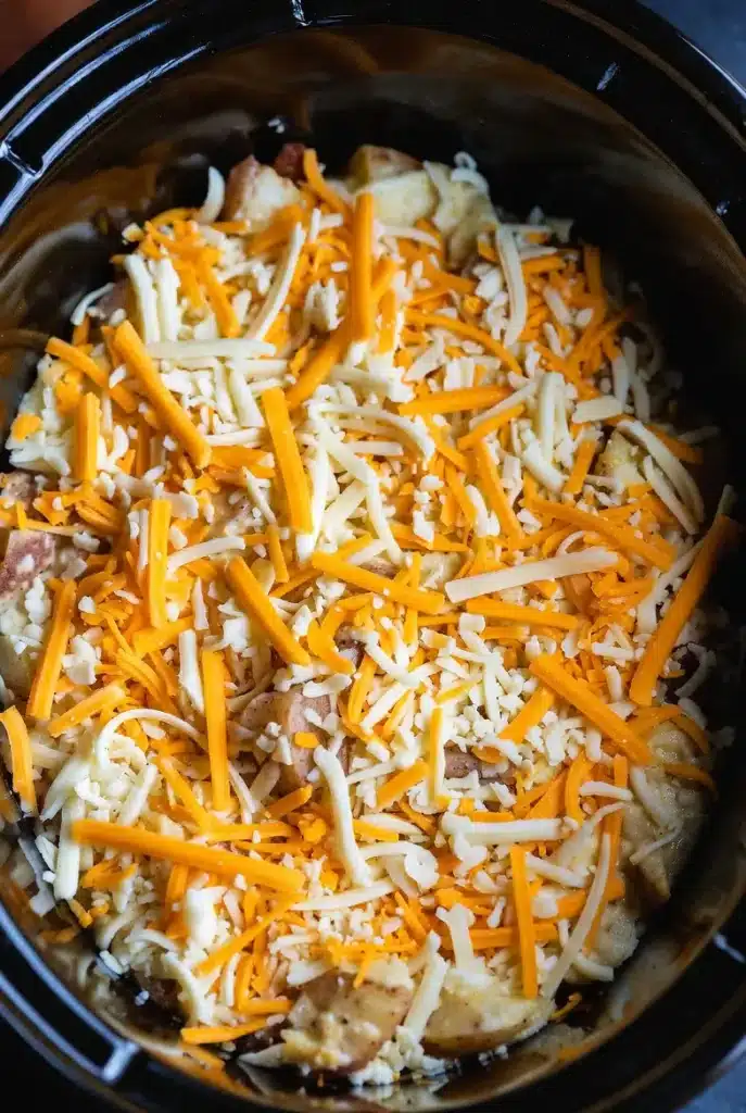 Easy Crockpot Swamp Potatoes (Creamy, Cheesy & Loaded) 12 shredded cheese and bacon added on top of potatoes