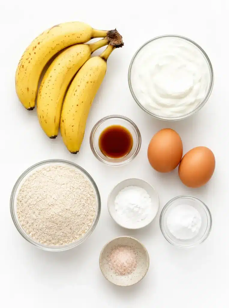 Bananas, Greek yogurt, eggs, oats, honey, and cinnamon arranged on a table