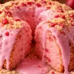 9 Amazing Secrets to the Ultimate Strawberry Cheesecake Bundt Cake (Bakery-Style Recipe) 6 Strawberry cheesecake bundt cake with creamy strawberry glaze dripping over a sliced cake filled with cheesecake swirls and fresh strawberry pieces.