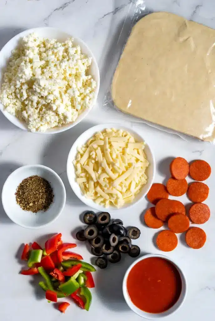 ingredients for pizza bites including dough cheese and toppings