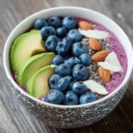 Colorful smoothie bowl topped with berries, banana slices, chia seeds, and granola