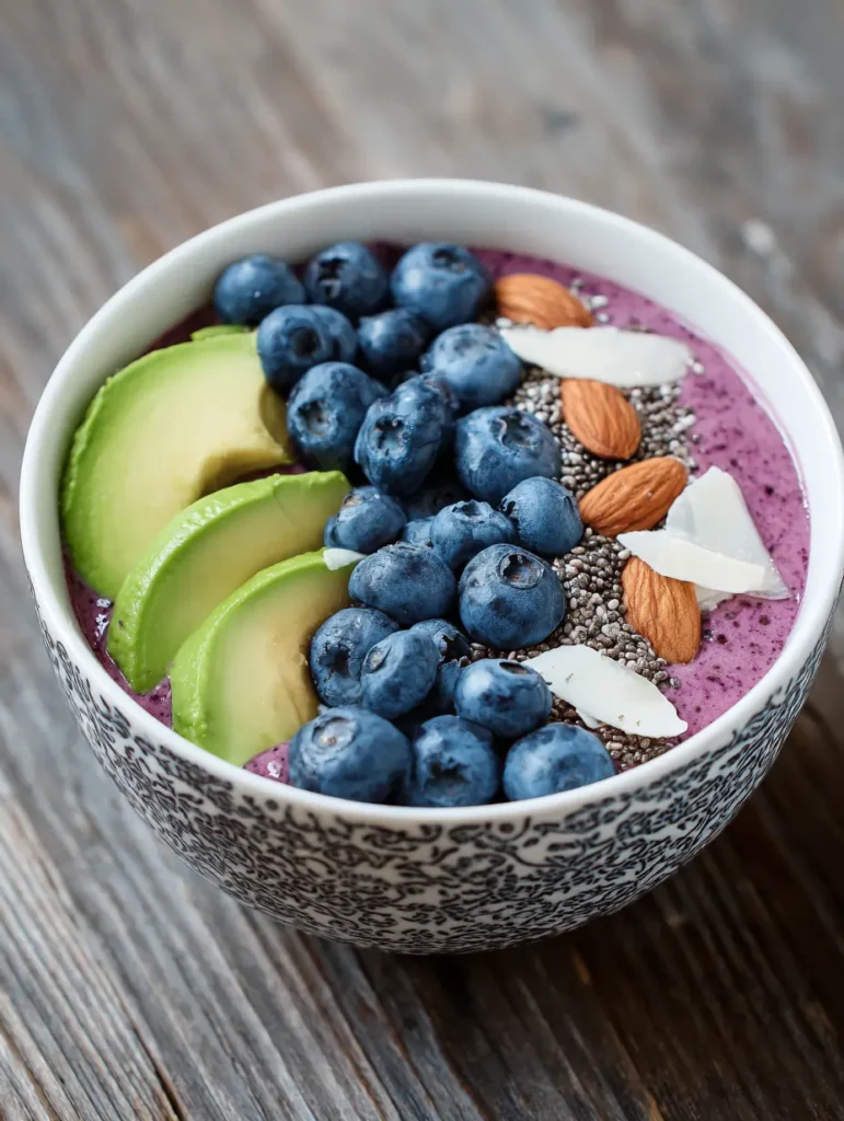 Colorful smoothie bowl topped with berries, banana slices, chia seeds, and granola