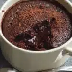 Fluffy and moist chocolate dessert in a mug, topped with chocolate shavings